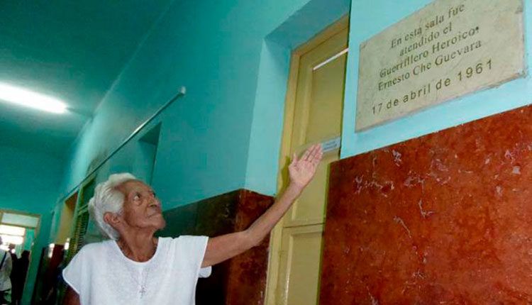 Olga muestra la tarja frente a la habitación en la que veló por la salud del Che. / Foto: Ronald Suárez Rivas