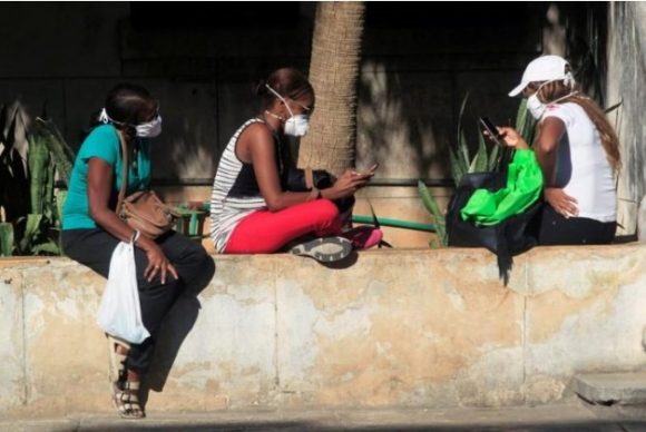 Science The Wire: La respuesta del coronavirus en Cuba está avergonzando a otros países Las personas usan sus teléfonos móviles con máscaras protectoras en medio de las preocupaciones sobre la propagación del brote de coronavirus, en La Habana, Cuba, el 19 de marzo de 2020. Foto: Reuters / Stringer