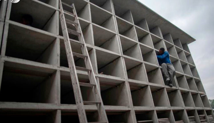 Un trabajador de la construcción realiza tareas en un nuevo conjunto de nichos fúnebres, en el cementerio de Cajú, en Rio de Janeiro, el 17 de abril de 2020. Foto: AFP/Archivos.