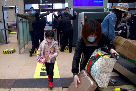 Pasajeros con mascarillas para protegerse del coronavirus pasan controles de seguridad en la estación de tren de Hankou luego de la reanudación del servicio, en Wuhan, en la provincia de Hubei, en el centro de China, el 8 de abril de 2020. Foto: AP.