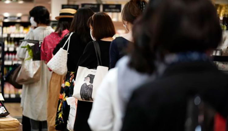COVID-19 en el mundo: España avanza en la desescalada y reabre más de la mitad de sus playas Clientes manteniendo distancia entre ellas mientras esperan en fila para pagar en una sección de alimentación de los grandes almacenes Matsuya Ginza, que reabría parcialmente el lunes, 25 de mayo de 2020, en Tokio. / Foto: AP.