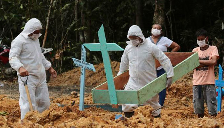 En esta imagen, tomada el 16 de abril de 2020, enterradores, vestidos con equipos de protección, preparan una tumba en el cementerio Nossa Senhora Aparecida para una mujer que se cree que murió por COVID-19, en Manaos, en el estado brasileño de Amazonas