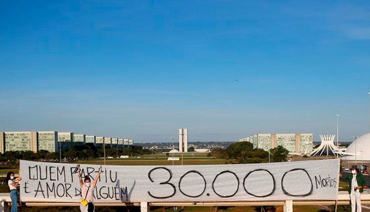 Artistas sostienen pancarta que dice "Quien partió, es amado por alguien", Brasilia, el 1 junio 2020. / Foto: Reuters.