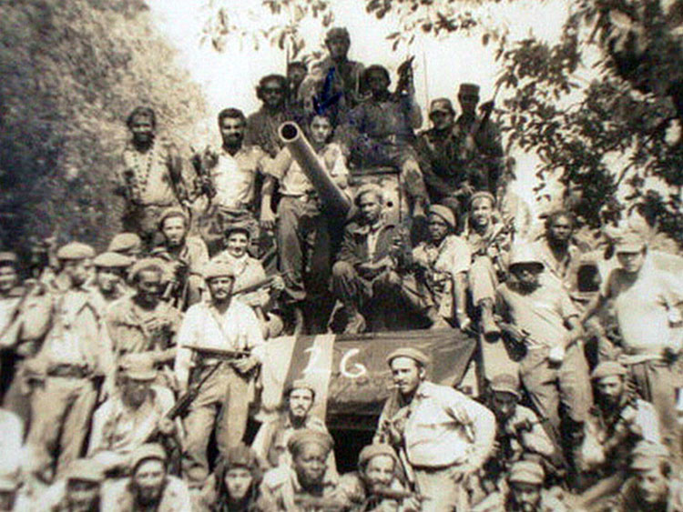 Un veterano de Girón Erasmo, de pie, recostado al cañón del tanque.