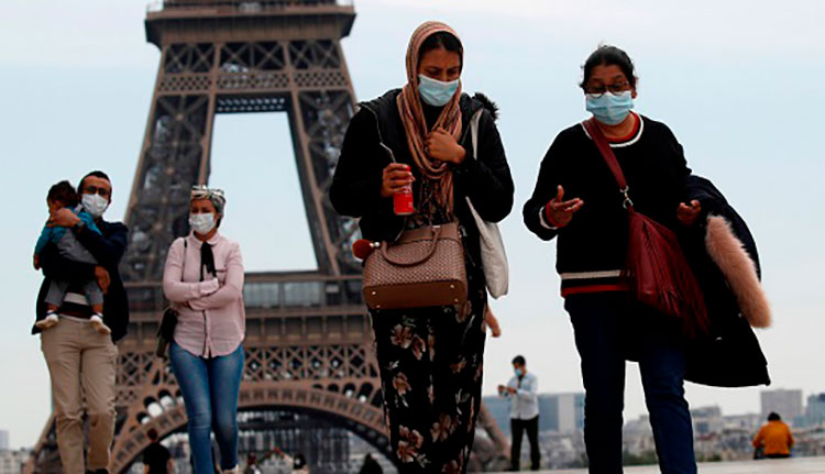 COVID-19 en el mundo: La OMS no tiene pruebas concluyentes de que el coronavirus se halle en superficies Personas con mascarilla caminan por la plaza Trocadero, cerca de la Torre Eiffel, en París (Francia), el 16 de mayo de 2020. / Foto: Reuters